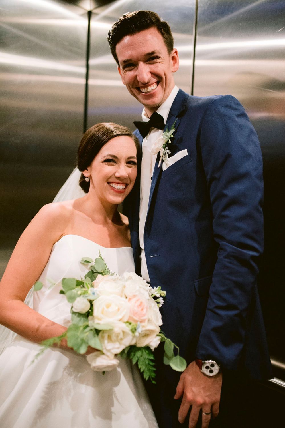 A series of candid wedding photos showing a couple in a navy suit and white dress posing together in an elevator.
