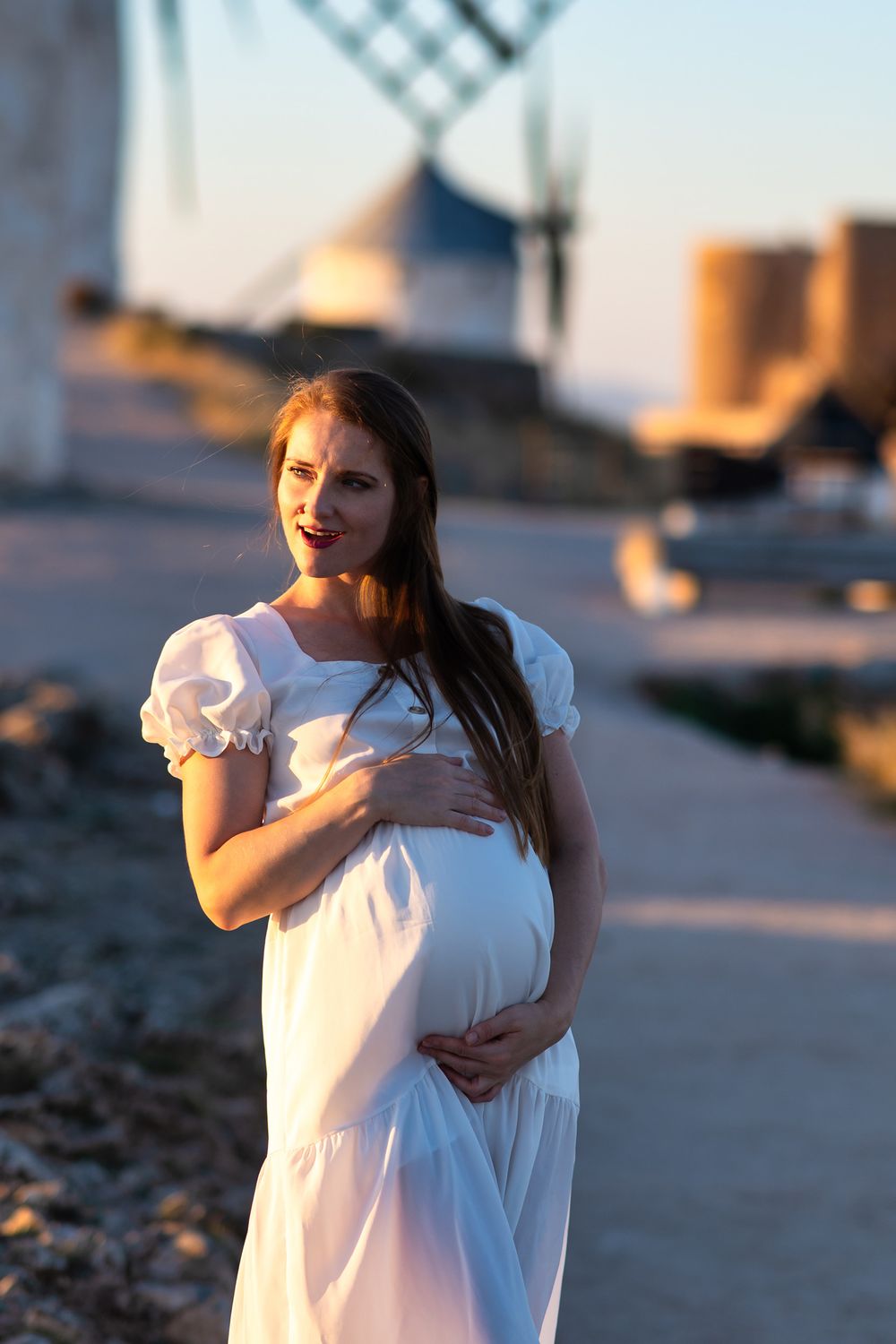 A person in a white dress stands on a rocky beach at sunset, shown in a series of connected photos.