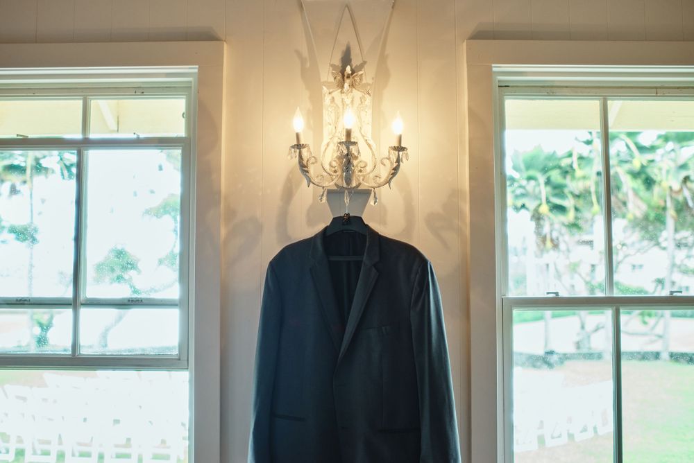 Elegant white interior room with chandelier and large windows for wedding preparations.