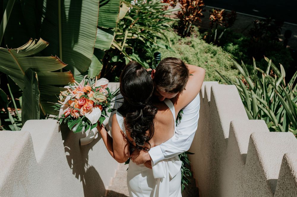 Elegant bridal portrait showing flowing white dress and tropical garden setting.