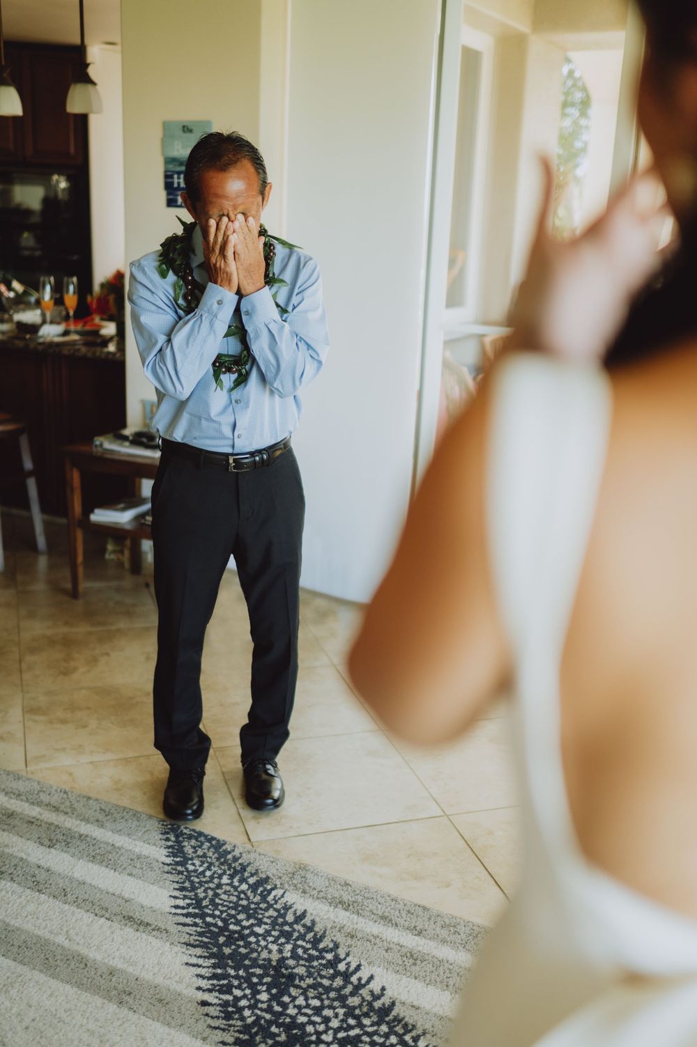 Emotional first look reaction during wedding day preparations in a bright interior.