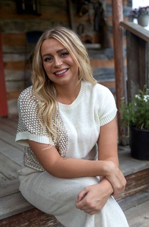 Casual portrait session on a rustic wooden porch featuring a white knit sweater and natural lighting.