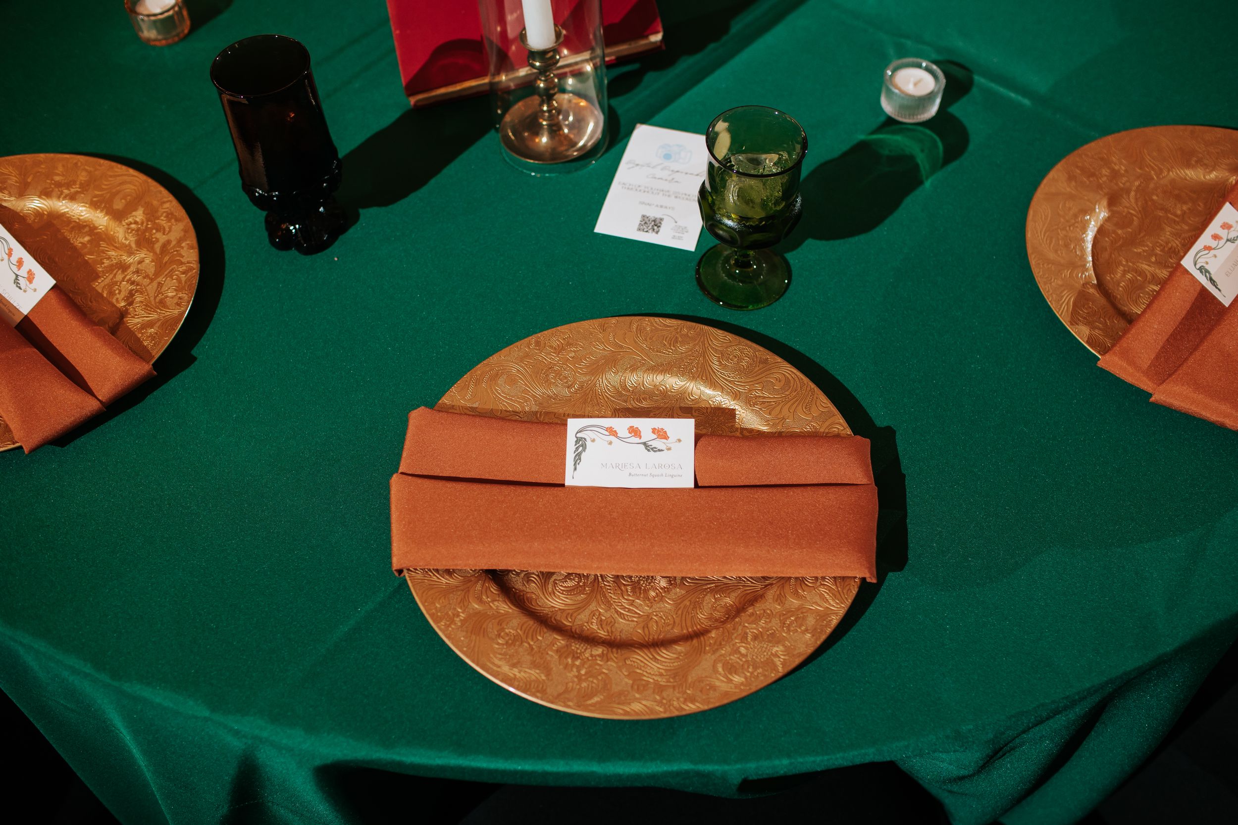 A collection of vintage vinyl records spread out on a green felt surface, showing their brown paper sleeves.