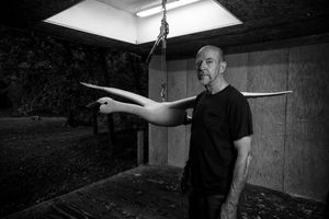 A series of black and white photos showing someone working in what appears to be a darkroom or photography studio.