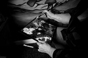 Black and white photographs of hands performing various actions and gestures against dark backgrounds.