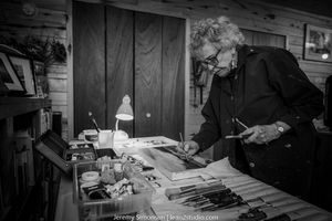A black and white montage of vintage workshop scenes showing tools, machinery, and hands at work.