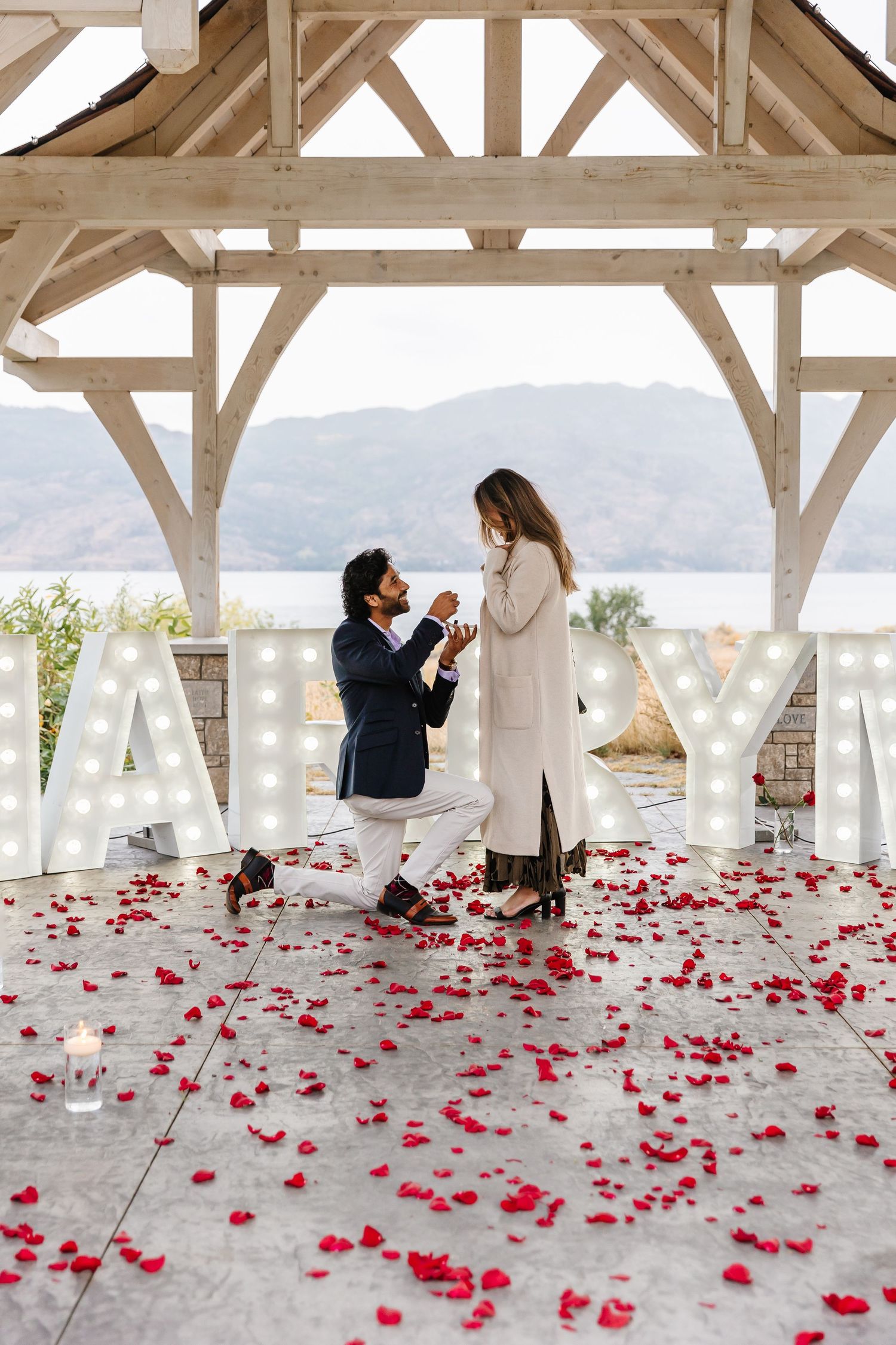A romantic outdoor engagement with mountain view under a gazebo at Sanctuary Gardens in West Kelowna for surprise proposal photoshoot