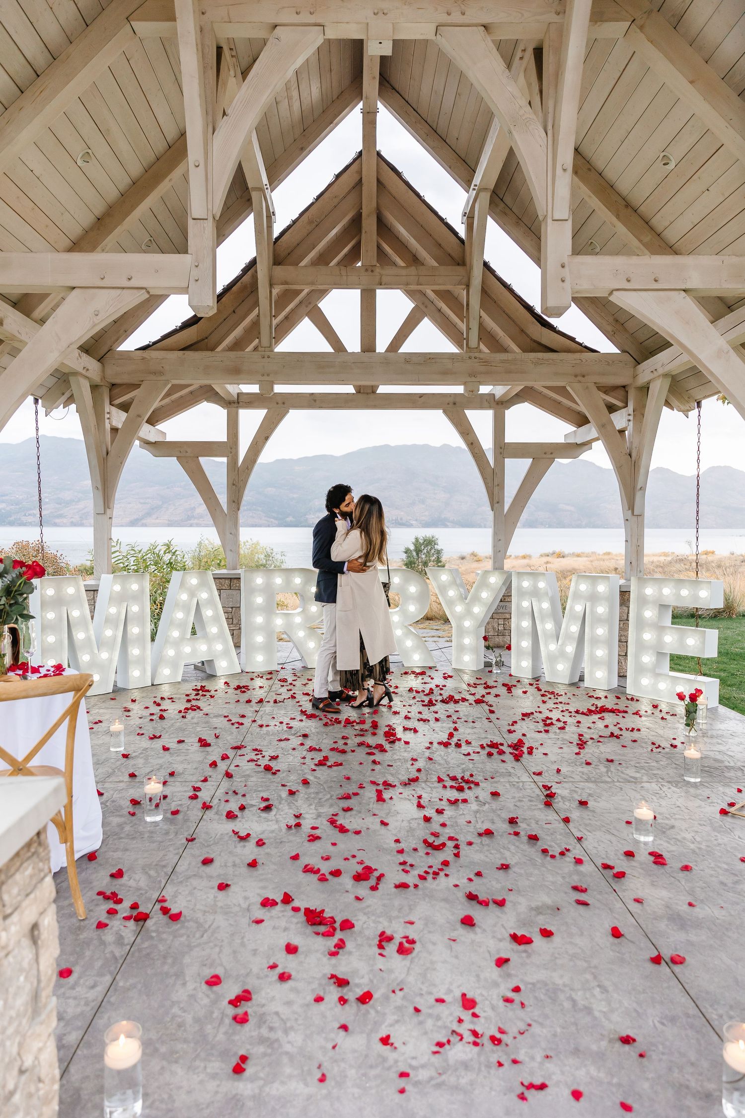 A romantic outdoor engagement with mountain view under a gazebo at Sanctuary Gardens in West Kelowna for surprise proposal photoshoot