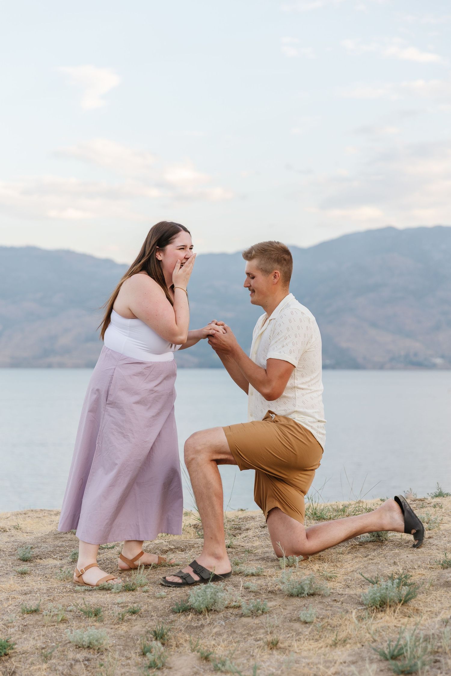 Romantic light and airy surprise proposal at Sanctuary Gardens in West Kelowna with a view of Okanagan Lake and the mountains.