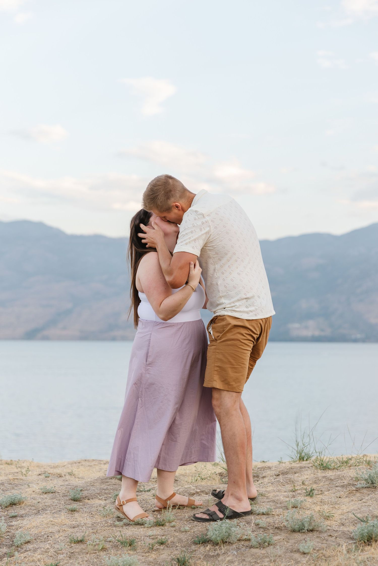 Surprise proposal at Sanctuary Gardens in West Kelowna, BC with a view of Okanagan Lake and the mountains at sunset in the summertime.