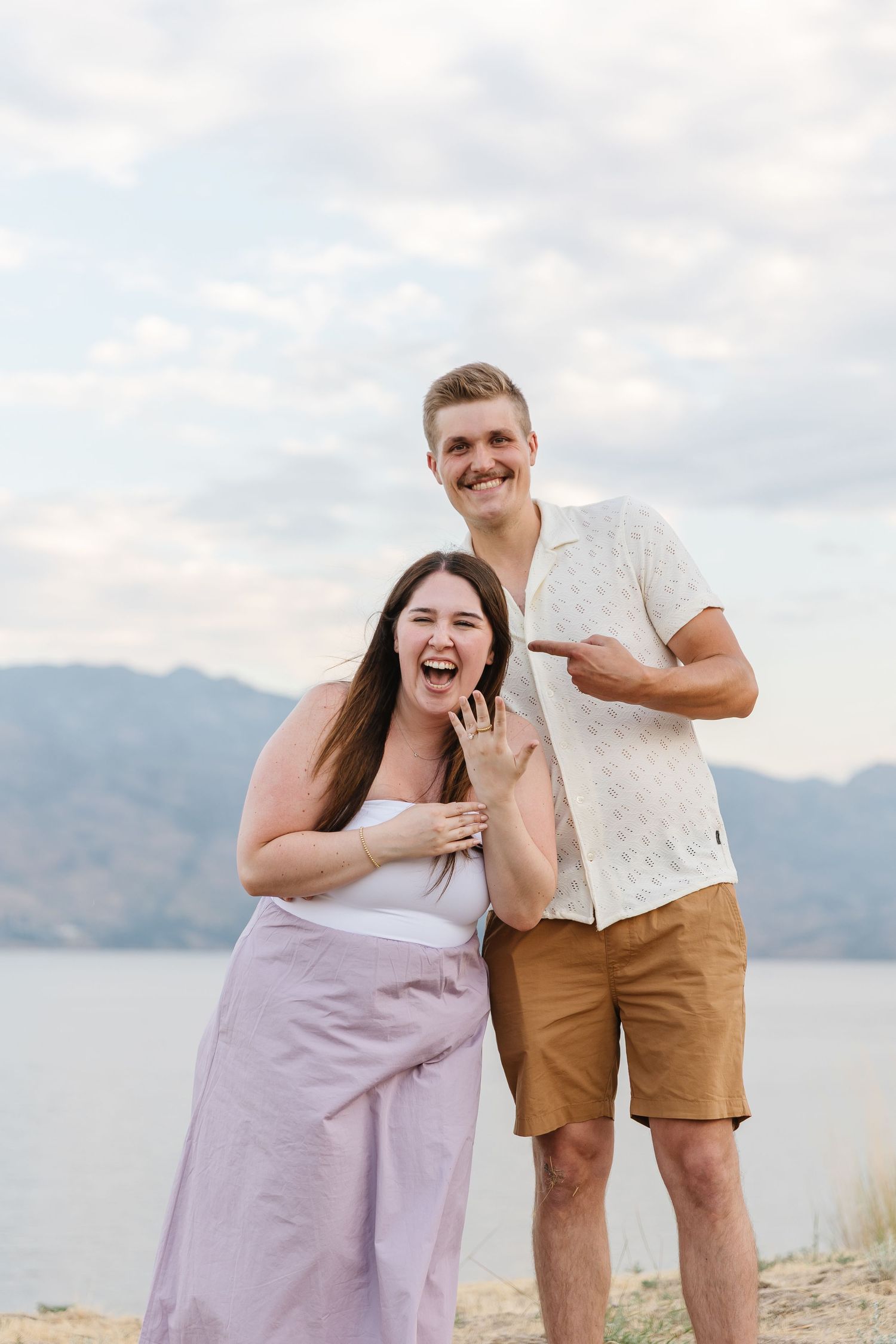 Surprise proposal reaction during a photoshoot at Sanctuary Gardens overlooking Okanagan Lake and a view of the mountains.