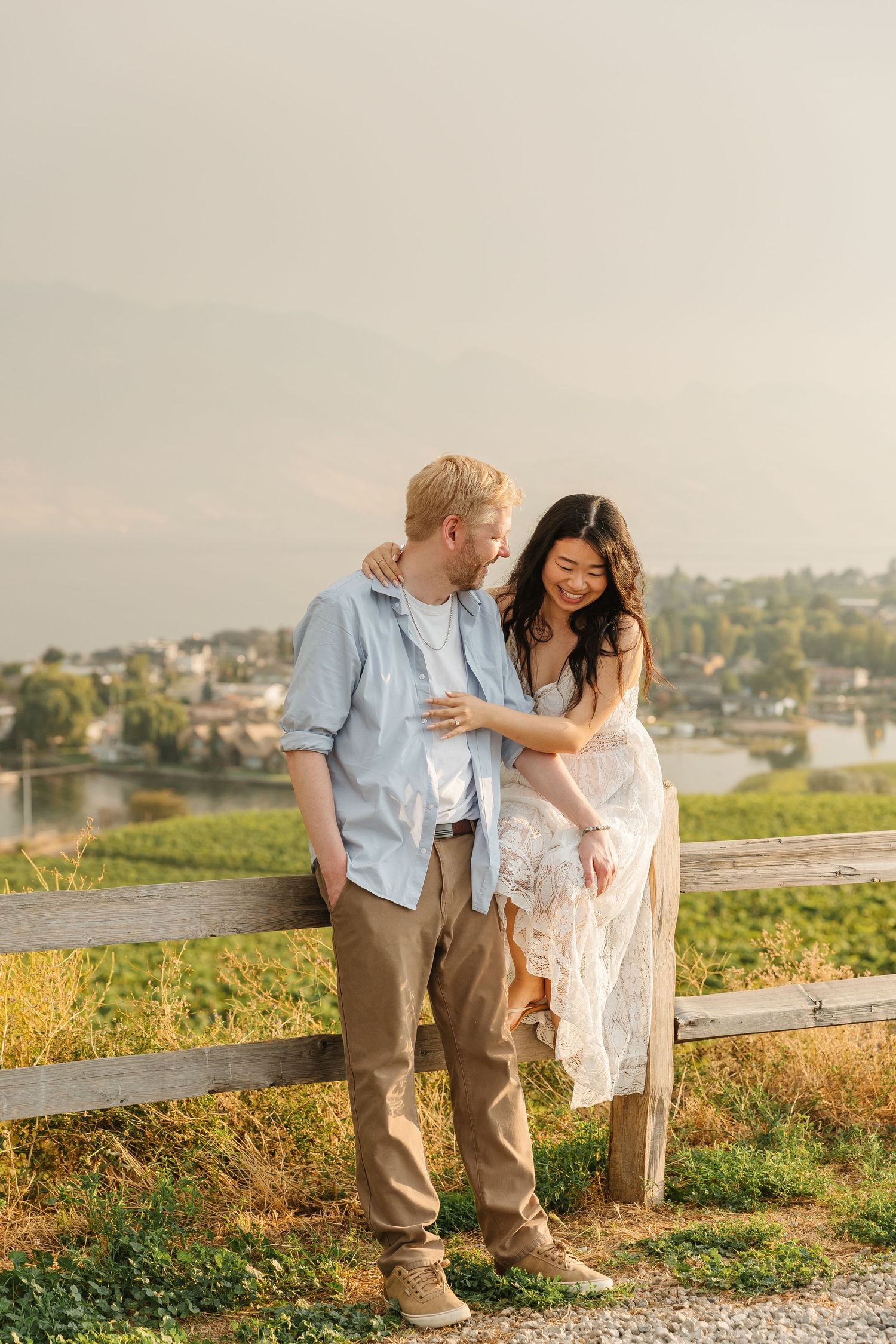 Romantic photos of a couple at sunset at Quails Gate Winery in West Kelowna, BC with a view of Okanagan Lake in the summer.