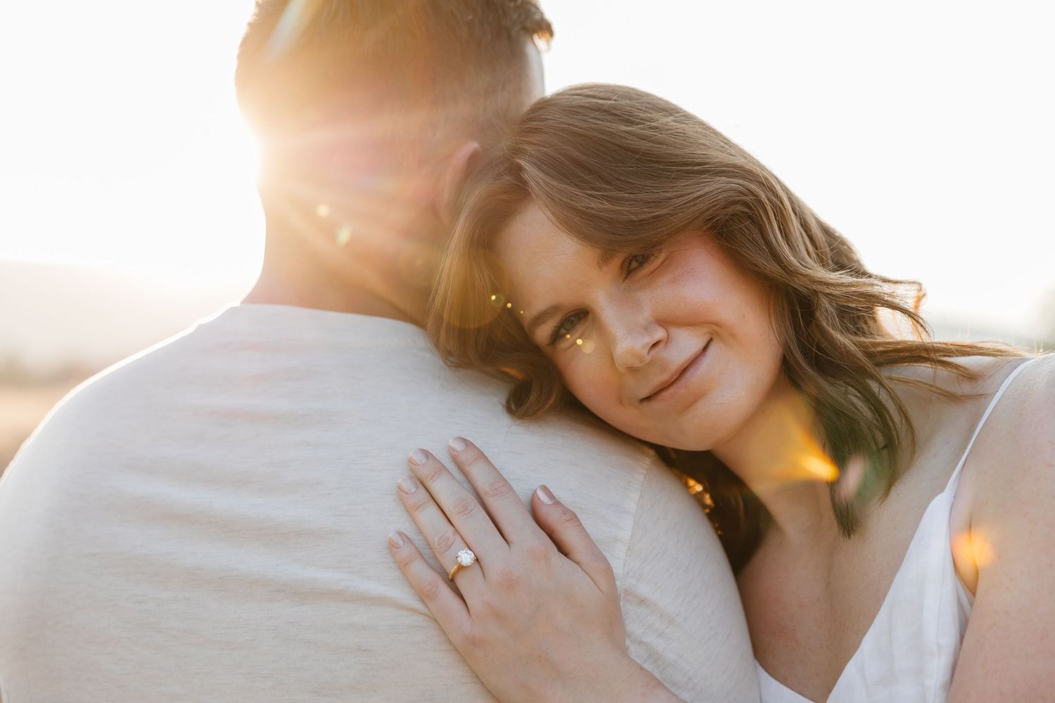 A couple poses in warm sunlight during a romantic outdoor photo session in West Kelowna, BC at Sanctuary Gardens.