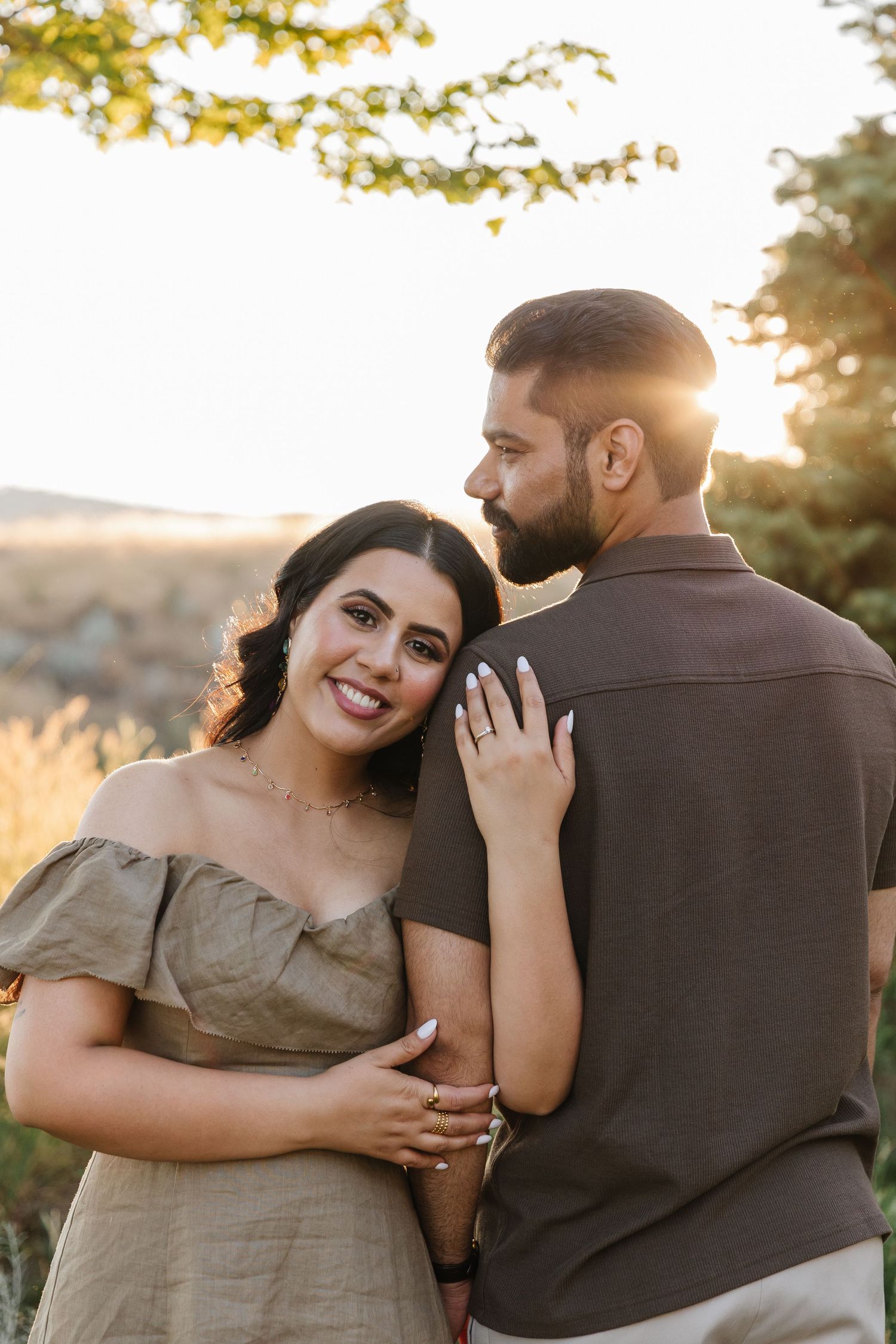 A couple poses during golden hour sunset in a natural outdoor  engagement photoshoot in West Kelowna, BC at Sanctuary Gardens