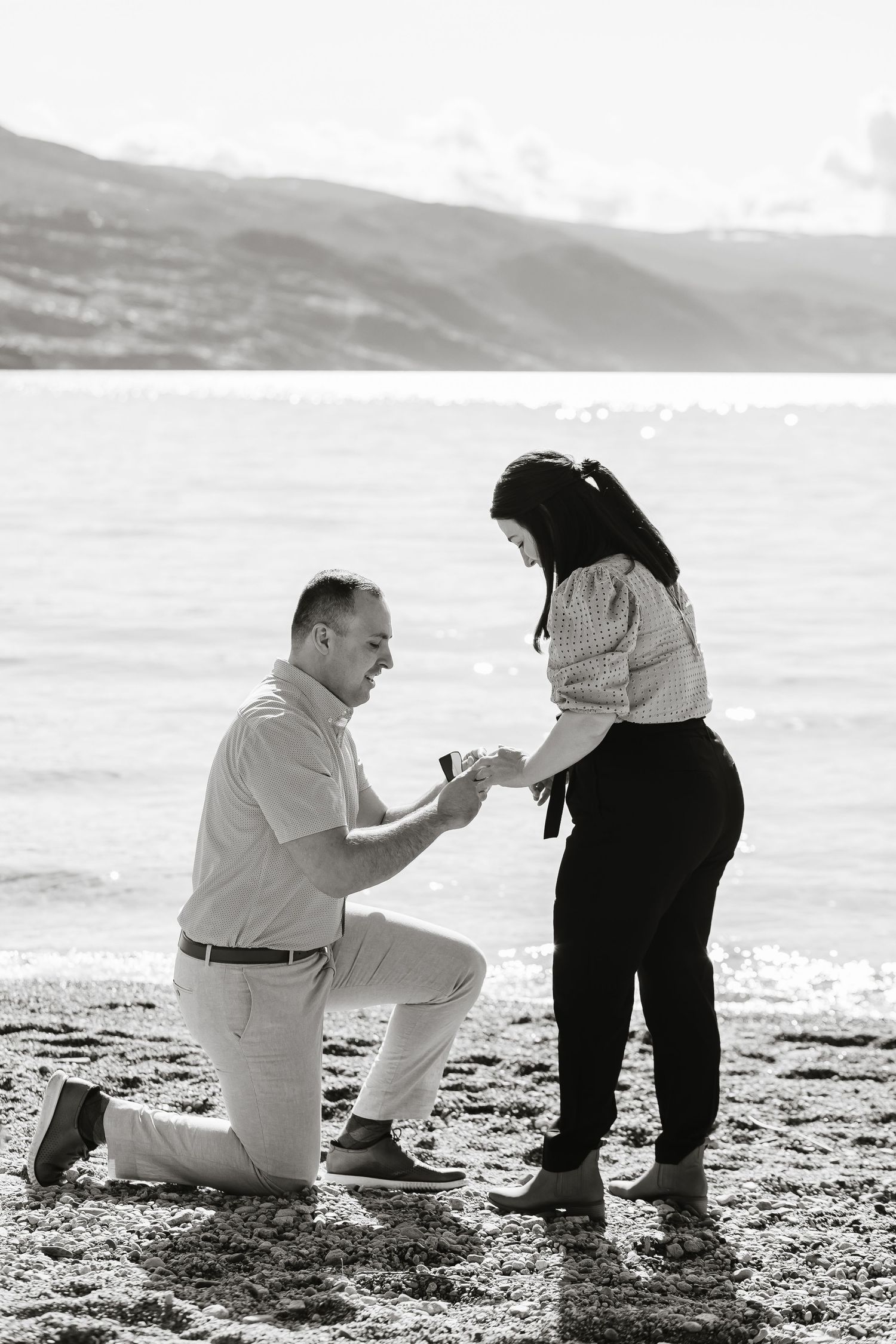 black and white proposal photos showing a couple on a beach in the Okanagan during a surprise proposal photoshoot