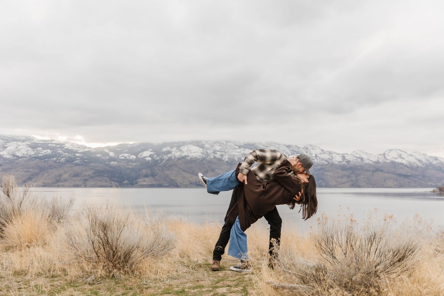 Surprise proposal photography with a view of Okanagan Lake and the mountains in West Kelowna, BC at Sanctuary Gardens.