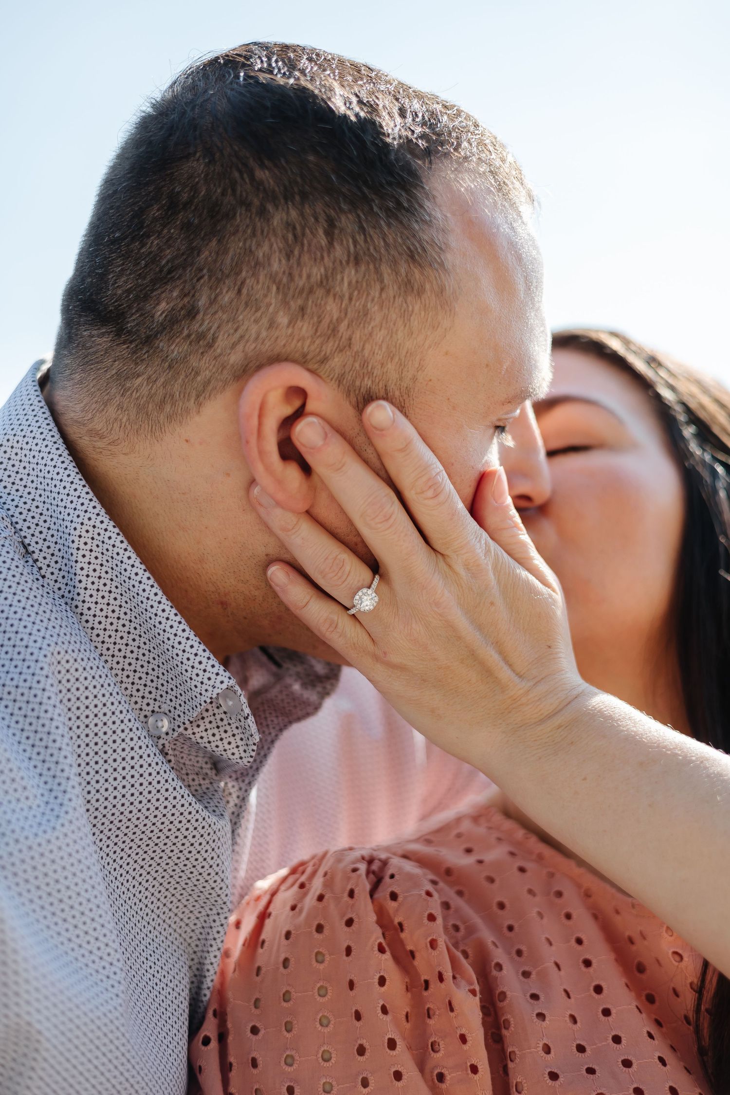 Romantic Engagment photo of a couple kissing after a surprise proposal at antlers beach in Peachland, BC