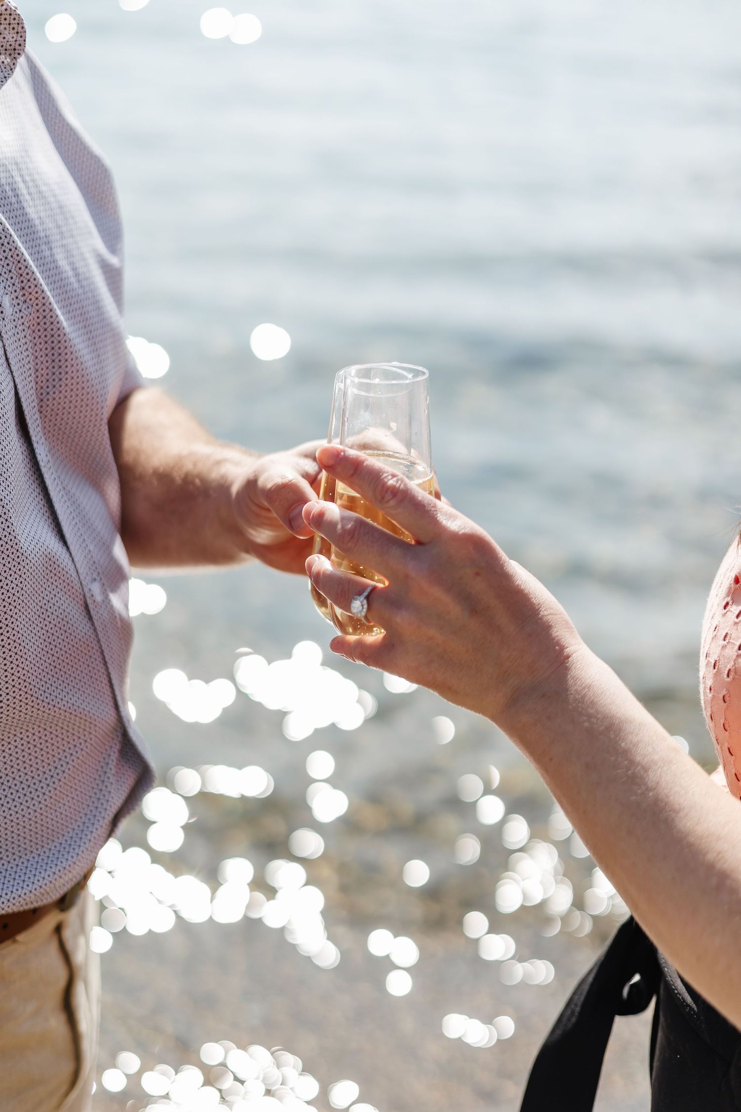 Champagne toast during an engagement session Peachland, BC with sparkling Okanagan lake water in the background