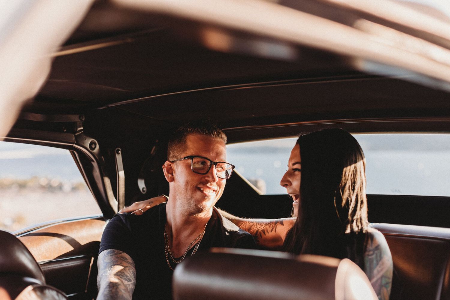 Couple sharing an intimate moment in a car during sunset with warm lighting in Kelowna bc for an Engagment session