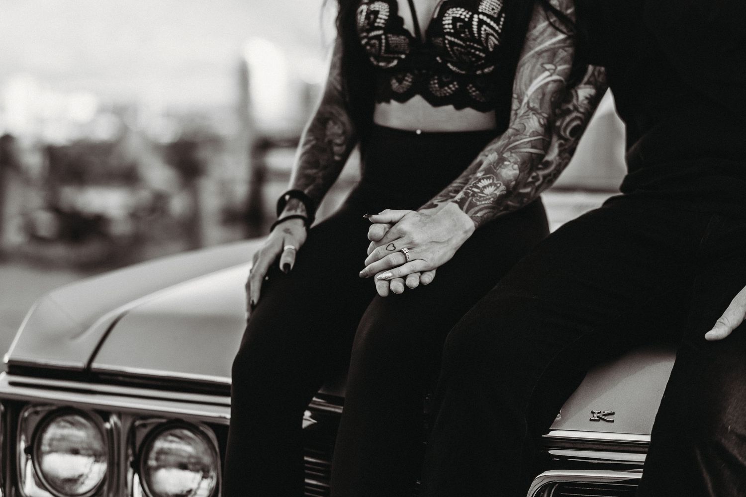Vintage black and white photograph showing people seated in a classic car with retro styling in Kelowna for an engagement photoshoot
