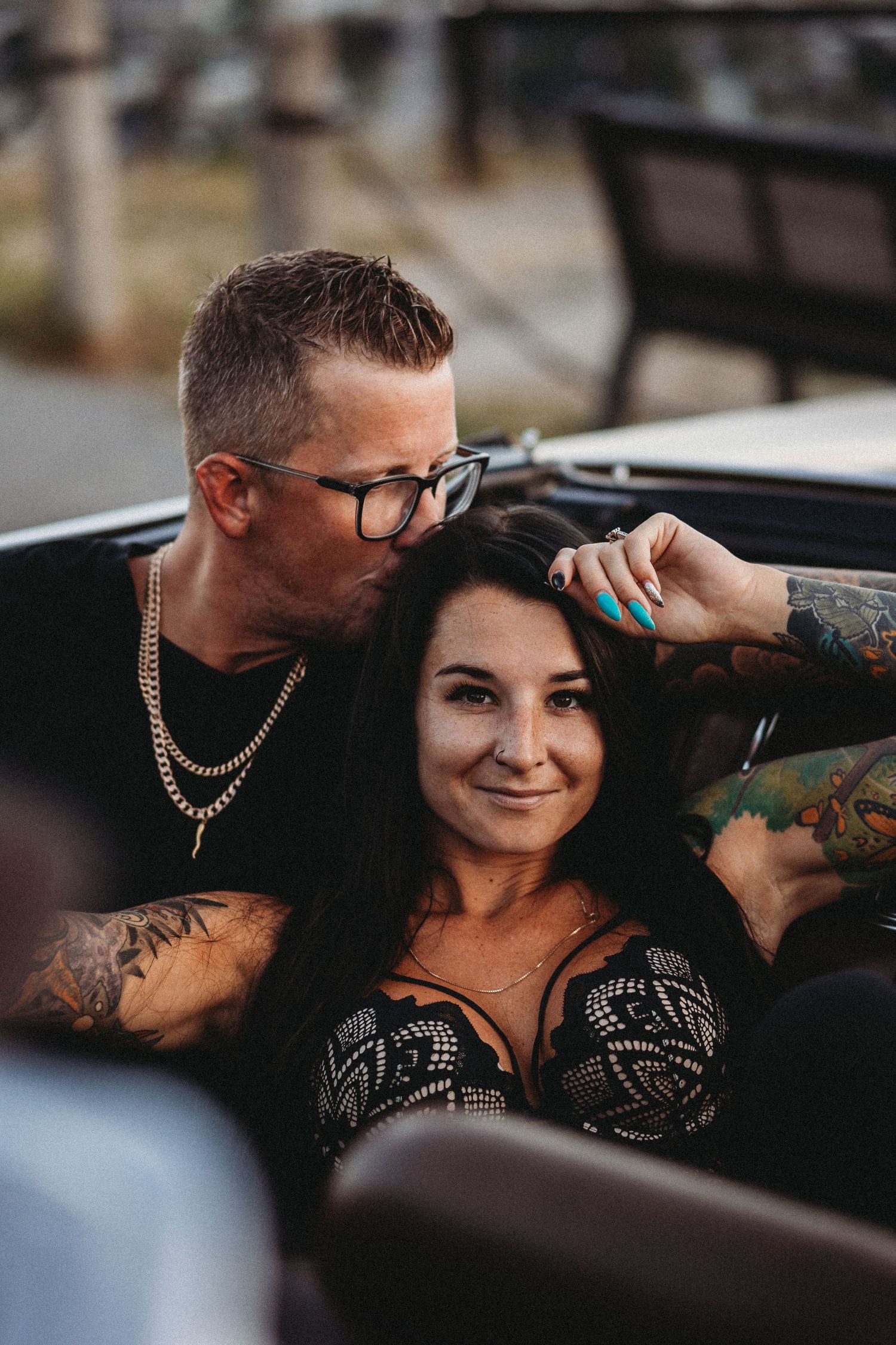 Engagement photo of a couple cuddled together in a vintage car during golden hour in Kelowna BC at Knox mountain