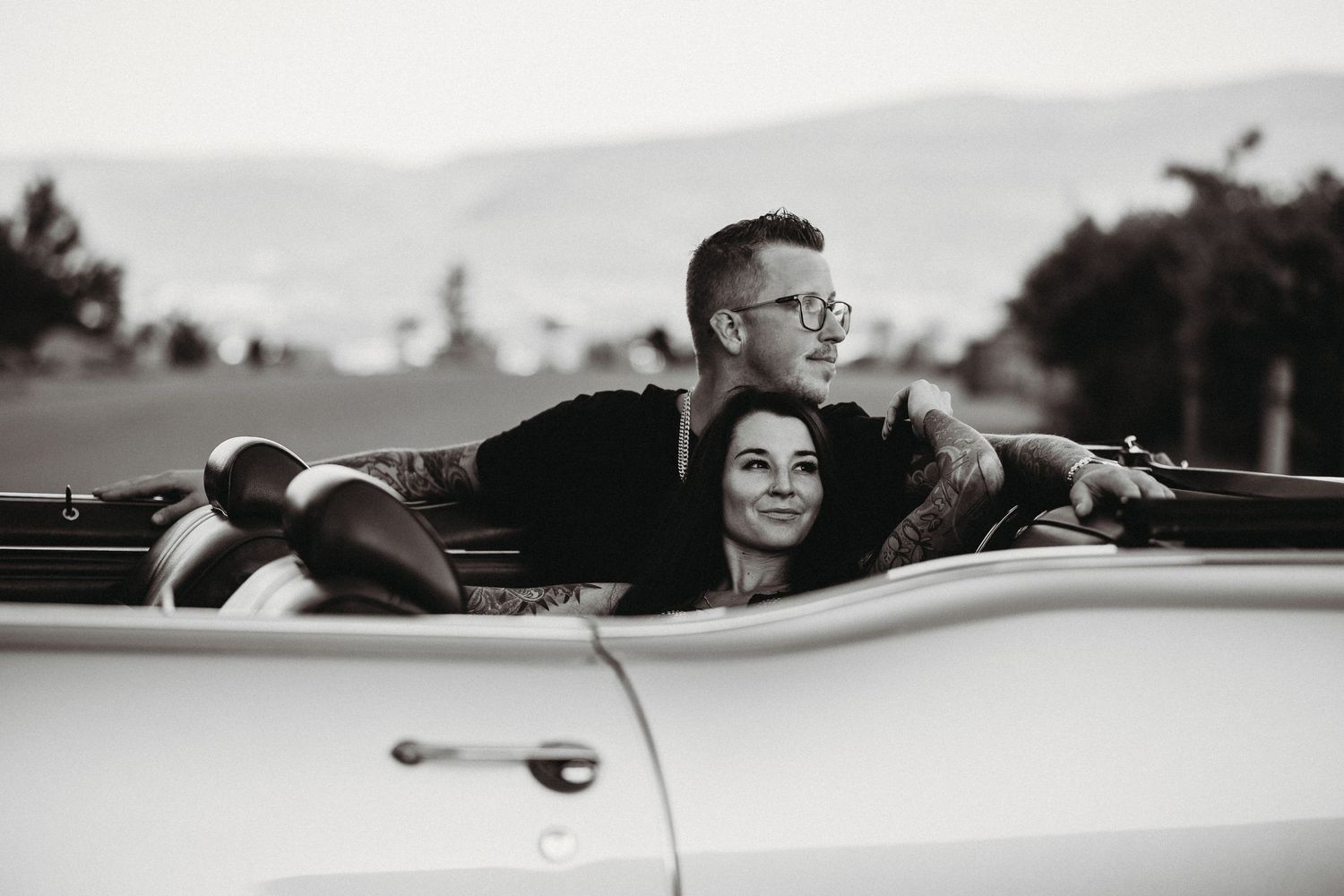Black and white engagement photo of a couple in a convertible at Knox mountain in Kelowna, BC.