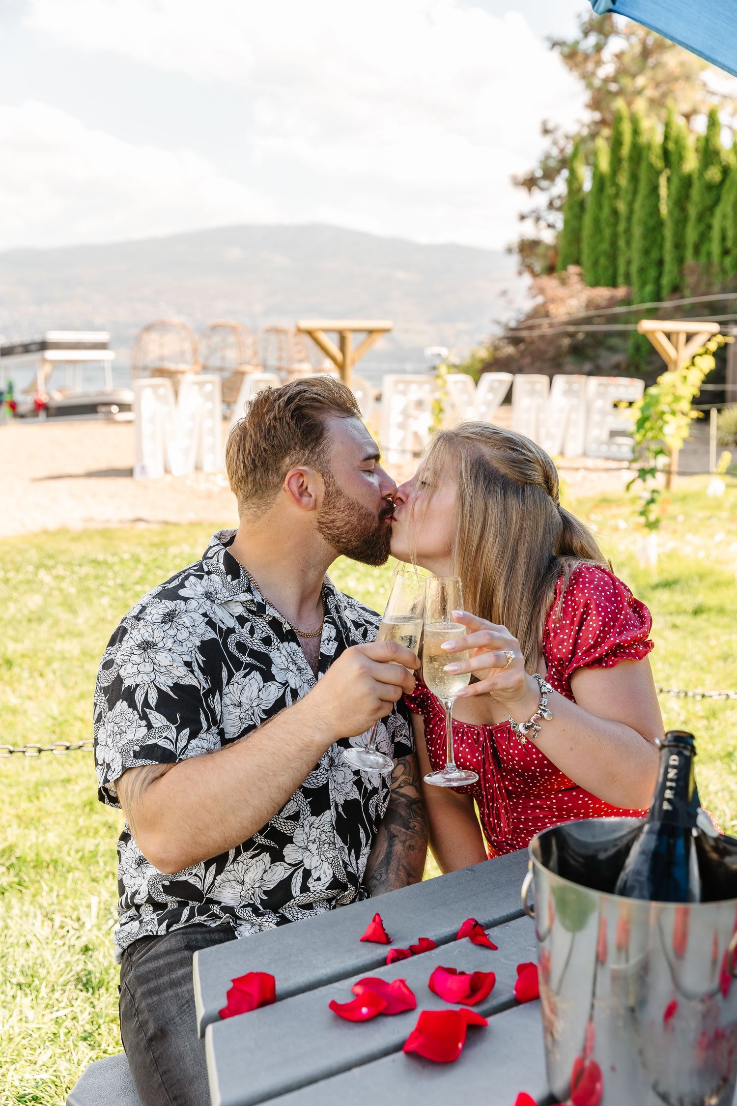 couple kissing to celebrate recent engagement after taking surprise proposal photos in West Kelowna bc