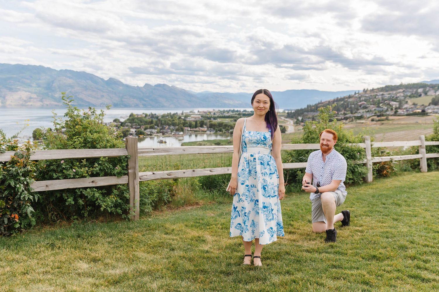 Photoshoot of Surprise proposal at Quails Gate Winery in West Kelowna, BC with a view of Okanagan Lake in the background.