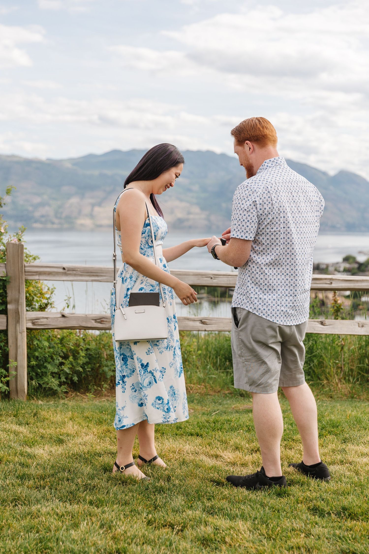 Photoshoot of Surprise proposal at Quails Gate Winery in West Kelowna, BC with a view of Okanagan Lake in the background.