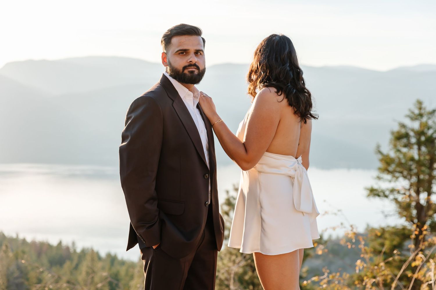 engagement photos at sparkling hills resort with view of Okanagan lake in the background in the summer