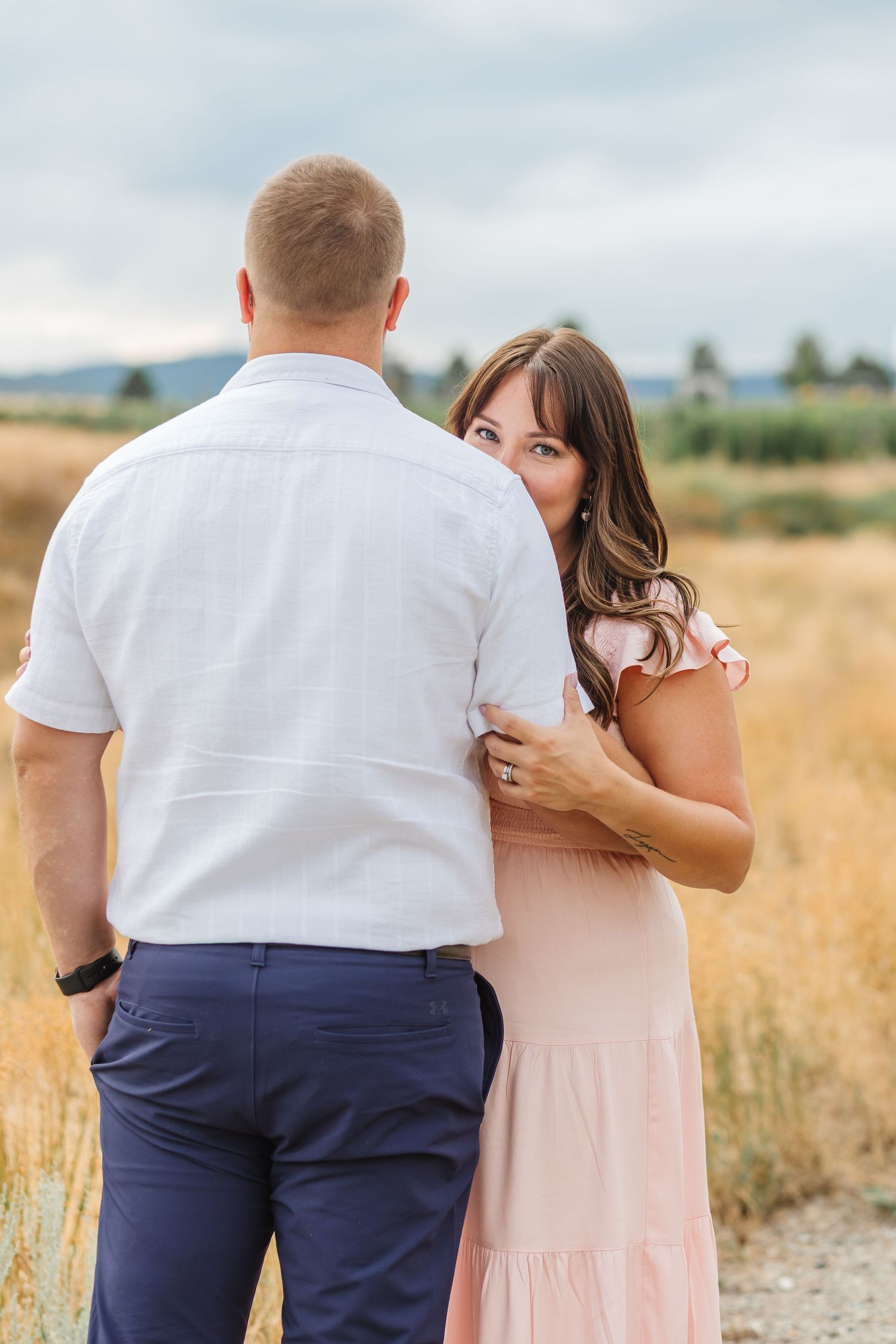 Engagement photos taken in brown grass in the field at Sanctuary Gardens in West Kelowna, BC