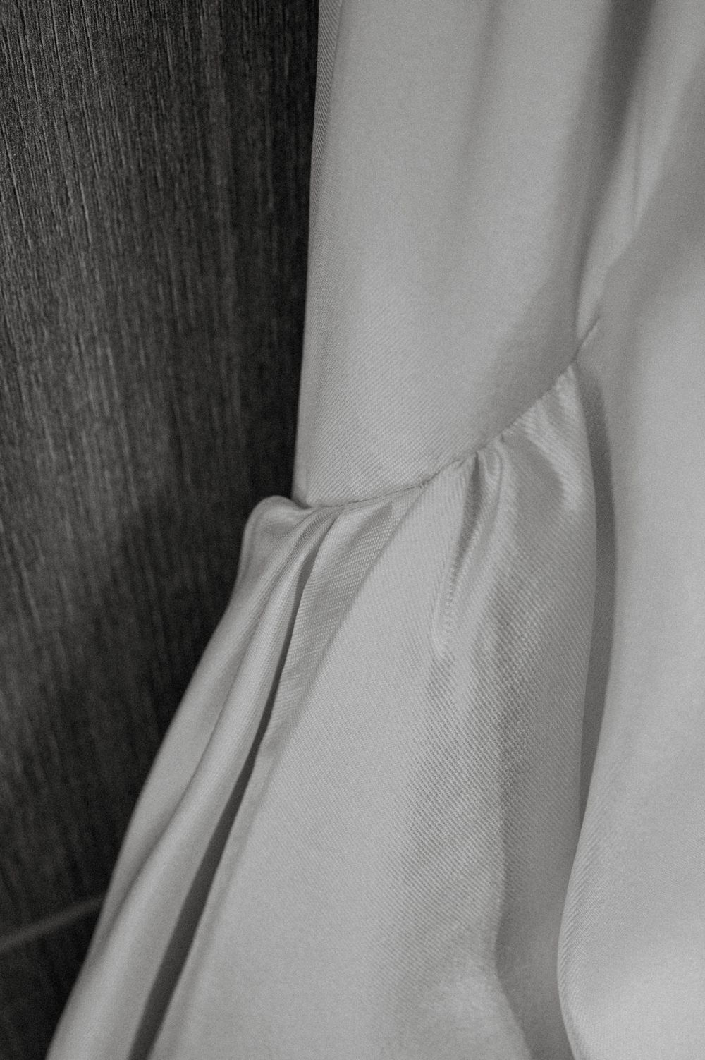 Close-up black and white detail of gathered fabric with soft pleats and folds creating delicate texture.