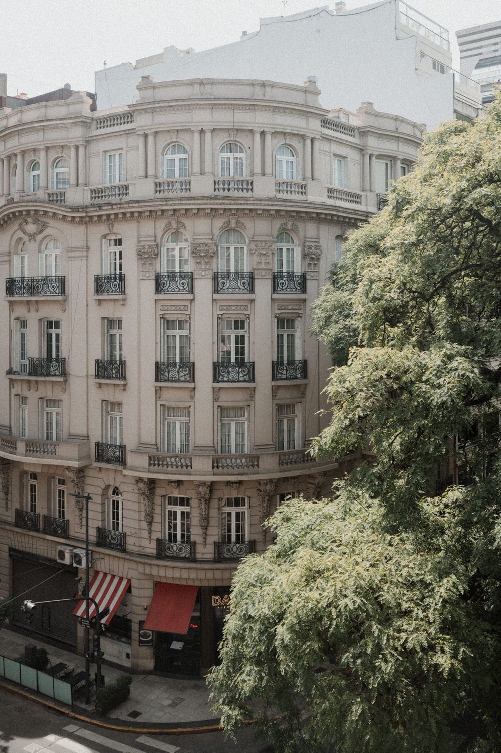Elegant Parisian-style apartment building with ornate architecture and curved facade featuring rows of arched windows and balconies.