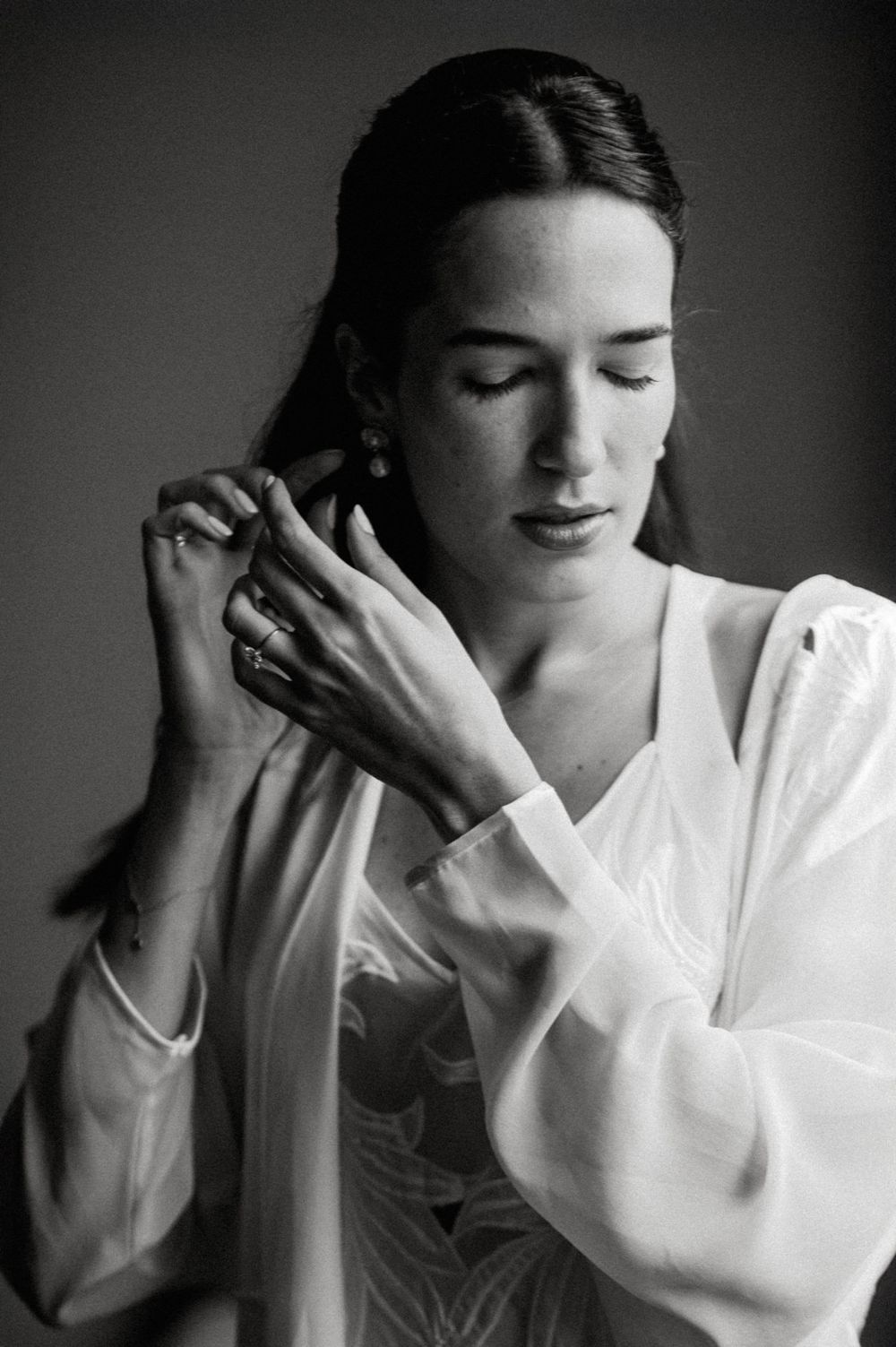 A black and white photo series showing a person in a white shirt making various emotional gestures with their hands.