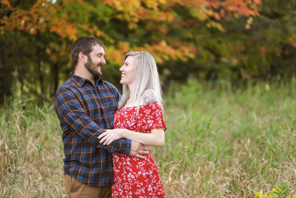 A romantic autumn portrait in a meadow with golden trees and fall colors creating a warm natural backdrop.