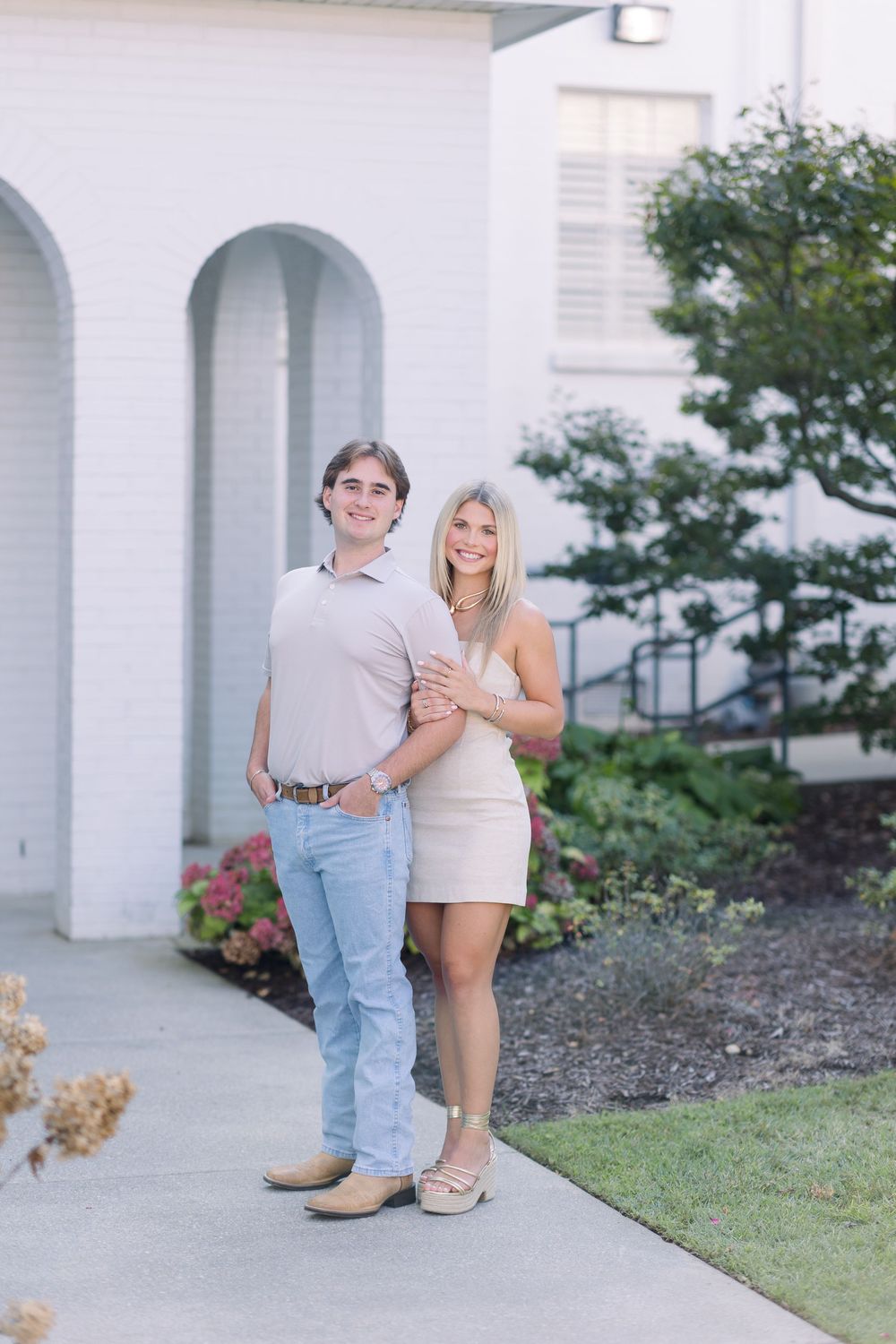 A couple shares a tender moment together on the steps of a white columned building during a photo session.