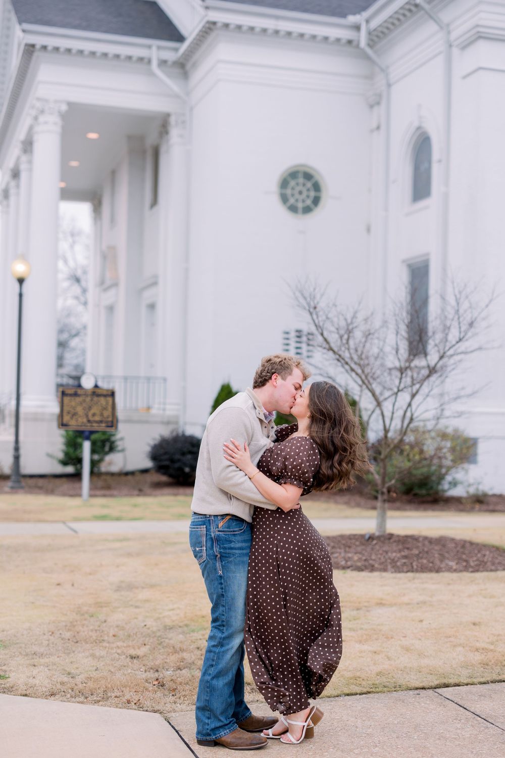 A romantic engagement sequence captured outside a grand white columned building with couples sharing tender moments.
