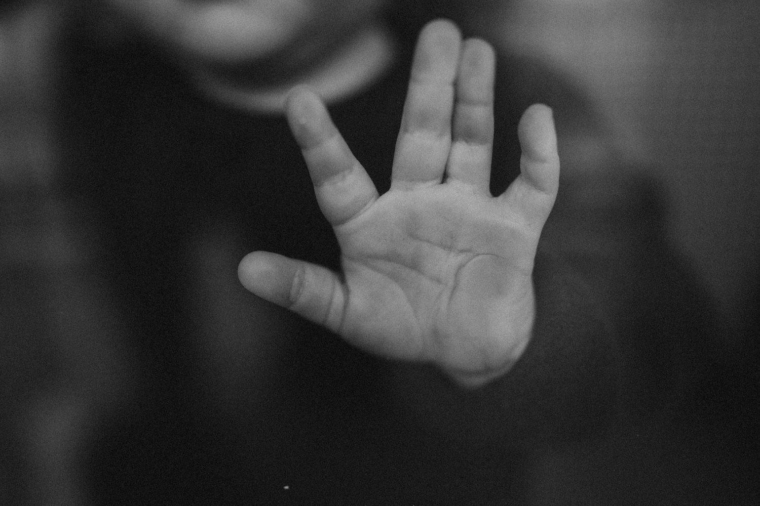 a close up of a baby's hand touching the window