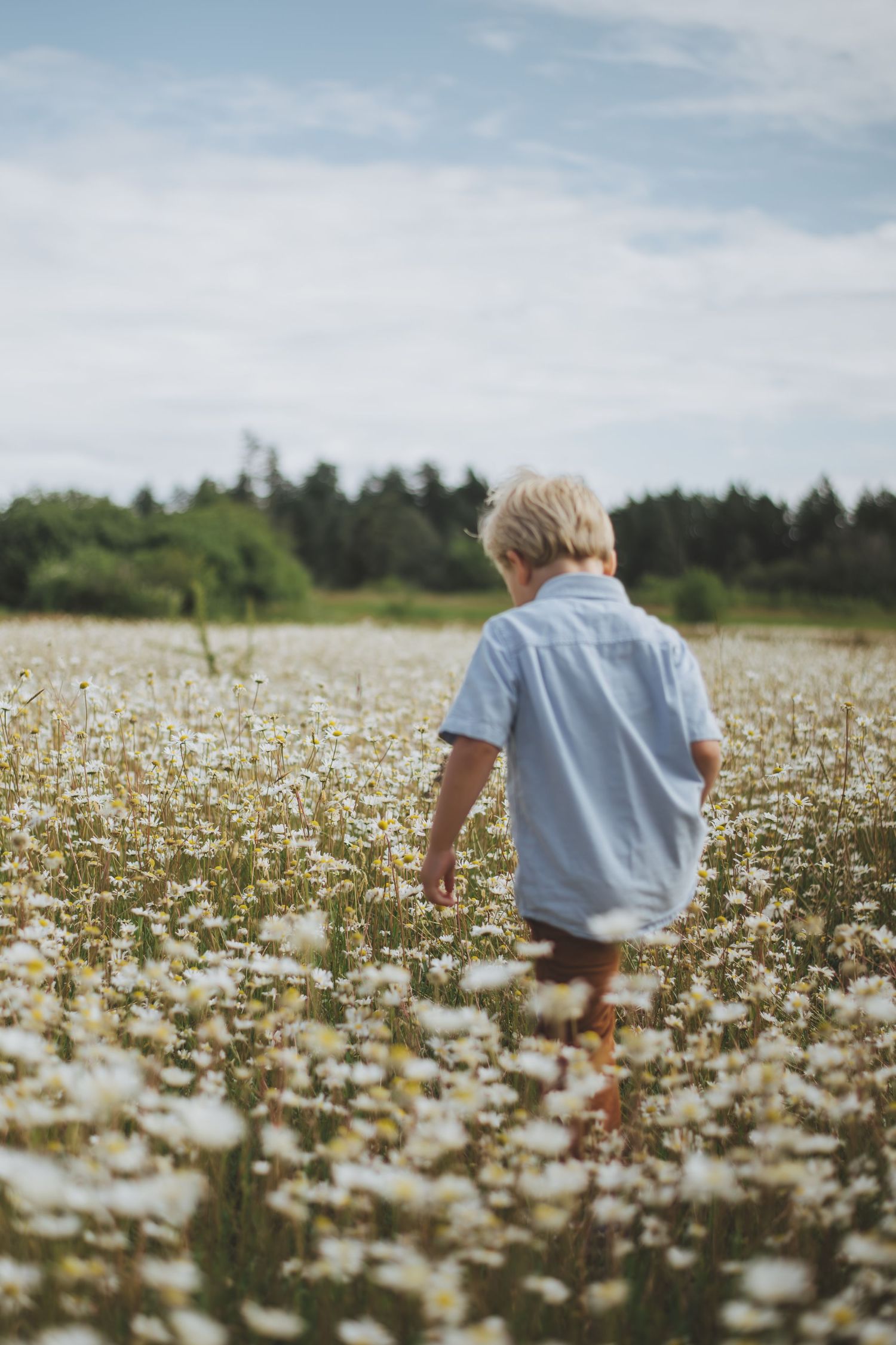 A heartwarming sequence of playful interaction between parent and child outdoors in soft beige and gray sweaters.