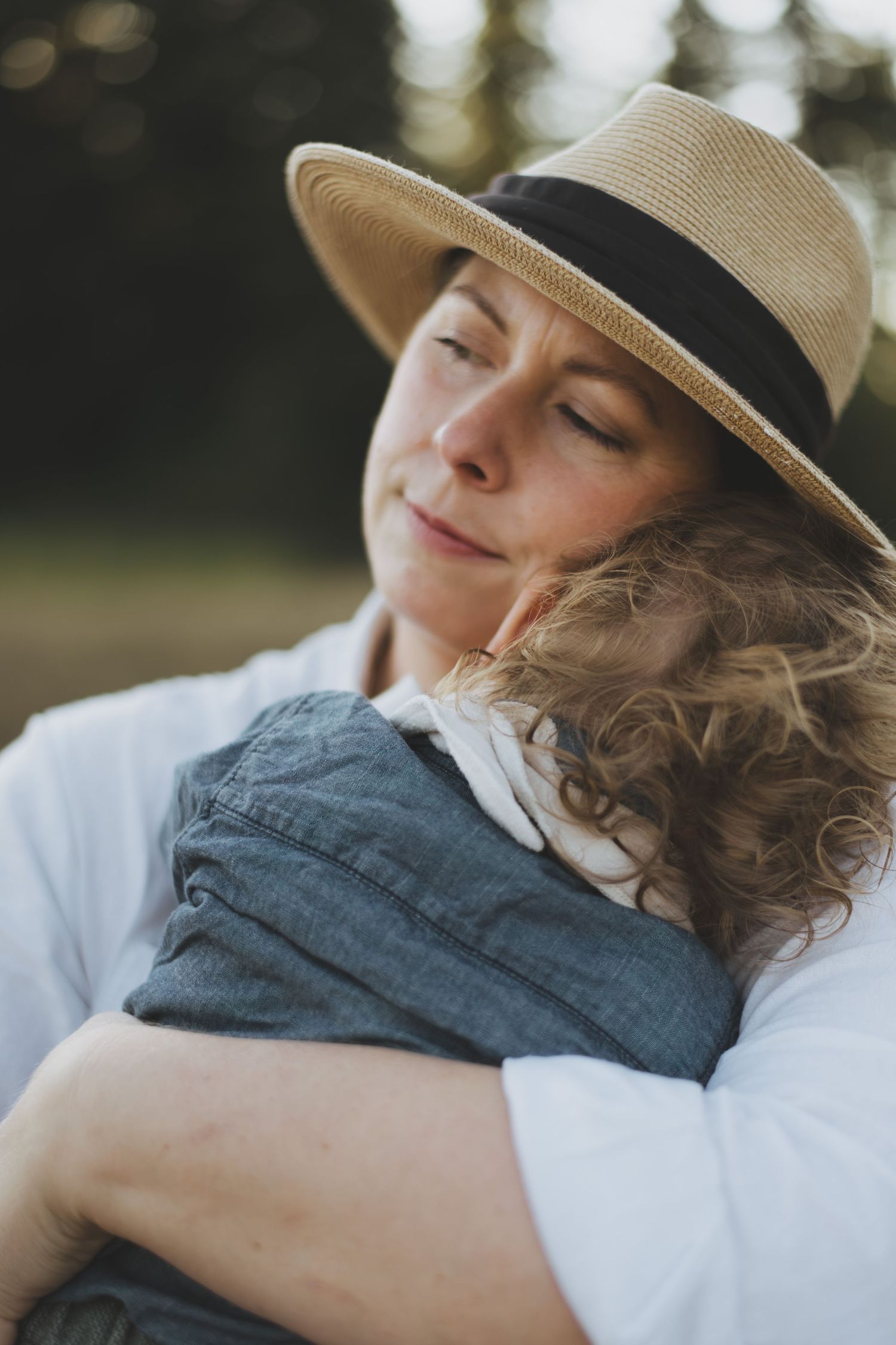 A heartwarming sequence of playful interaction between parent and child outdoors in soft beige and gray sweaters.