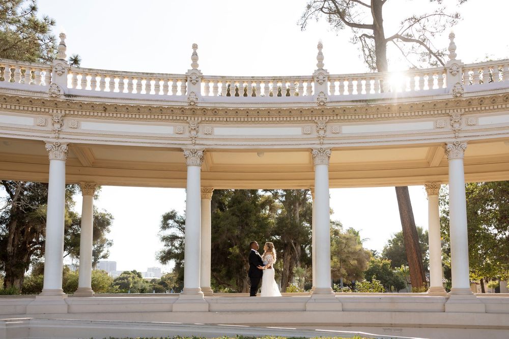 An elegant white colonnade with ornate architectural details curves around a garden setting.