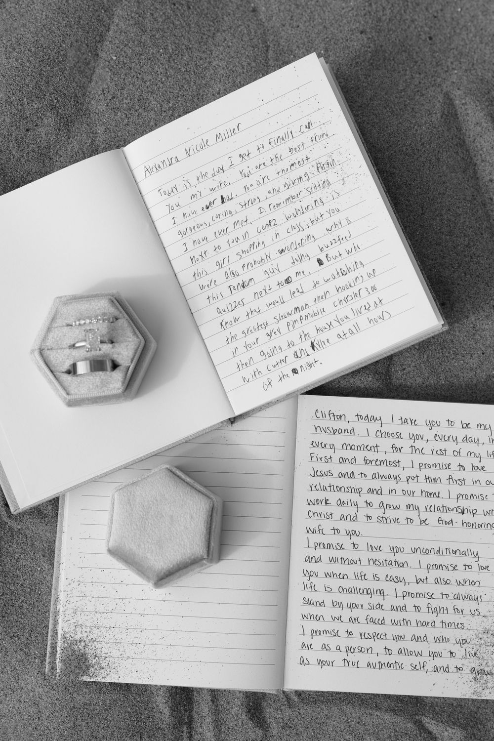 Wedding rings in hexagonal box next to handwritten notes on white paper against dark background.