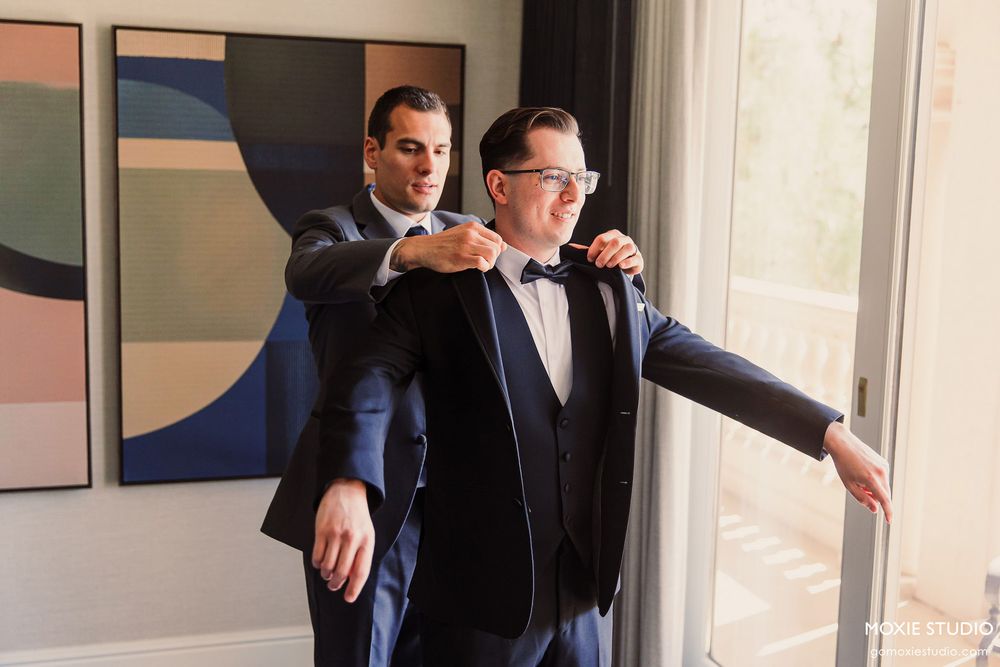 Professional business attire being fitted and adjusted in a bright modern studio setting.