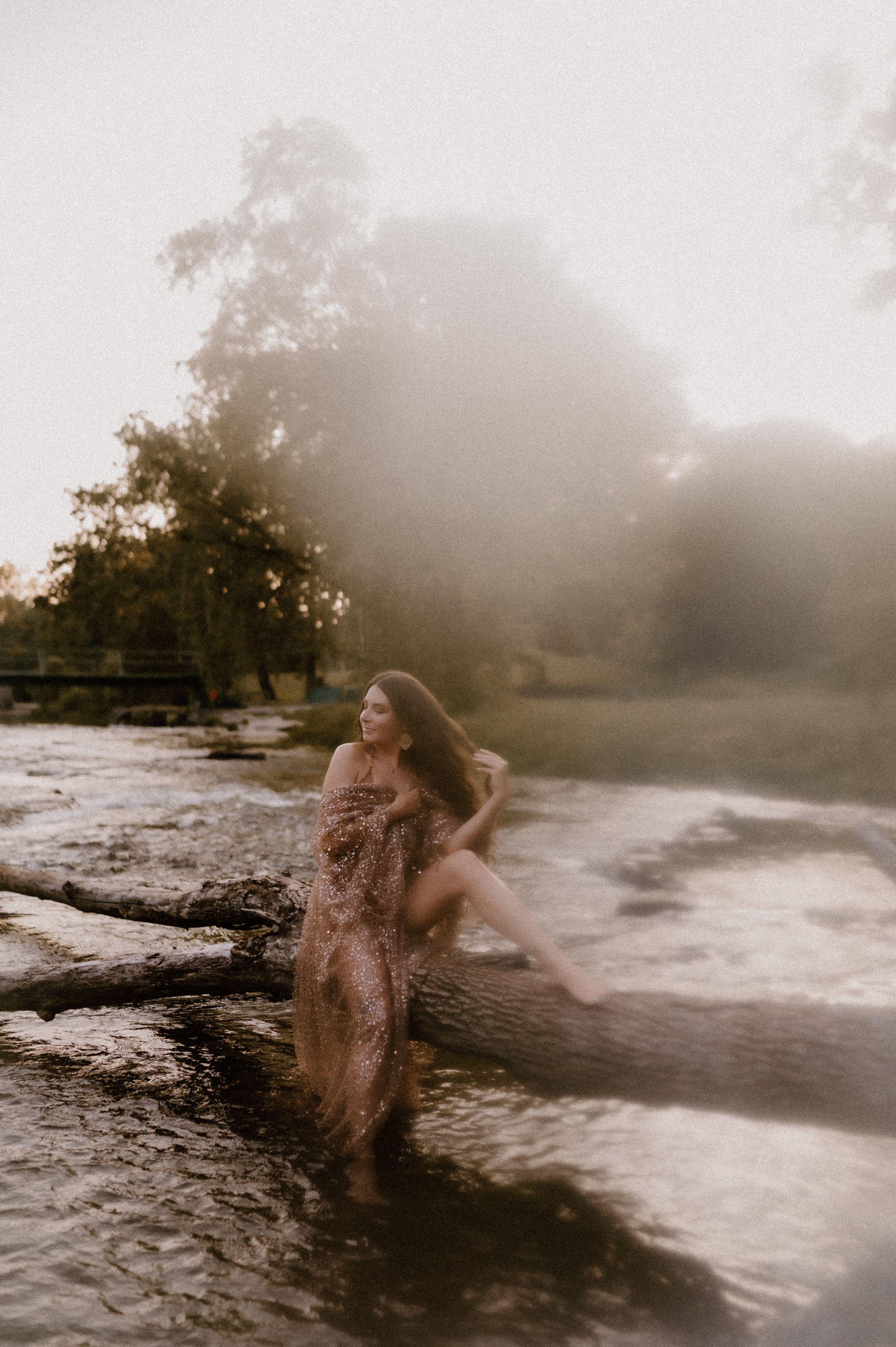 Ethereal beach scene with a figure in flowing dress dancing through misty ocean waves at sunset.