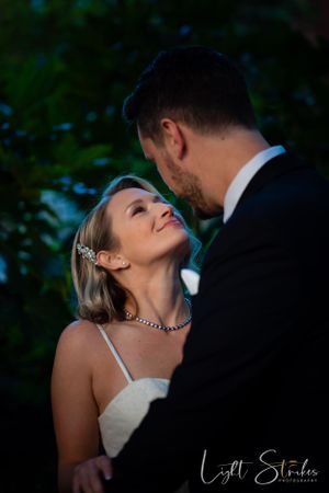 Charlotte wedding photographer captured a romantic wedding couple share an intimate moment at twilight in a garden setting.