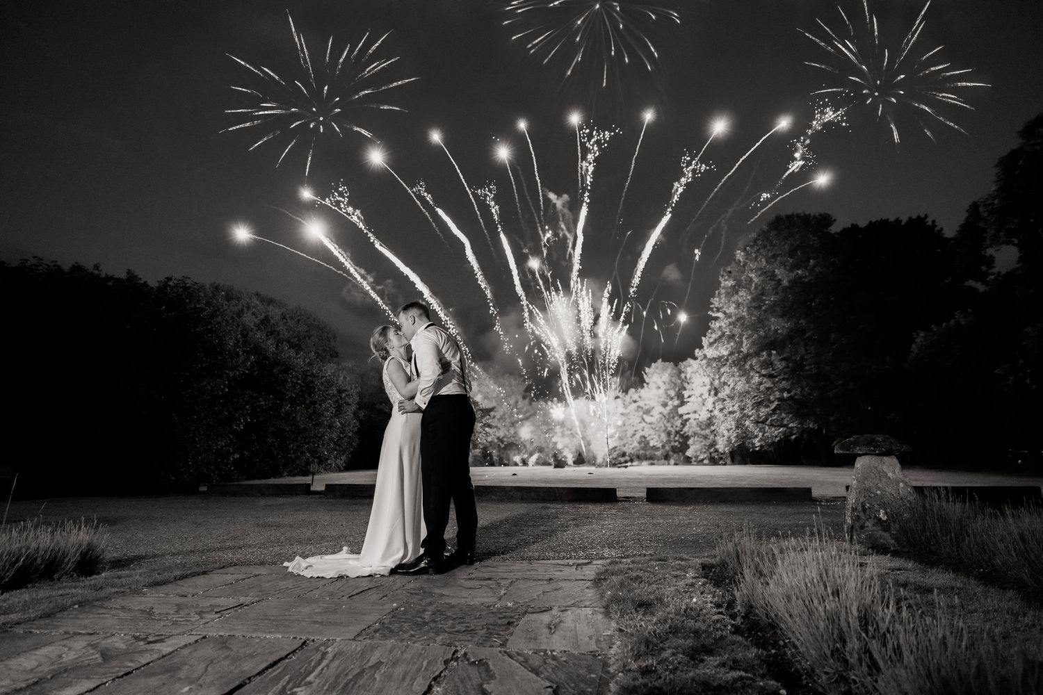 Dramatic black and white photograph of fireworks display during an evening celebration.