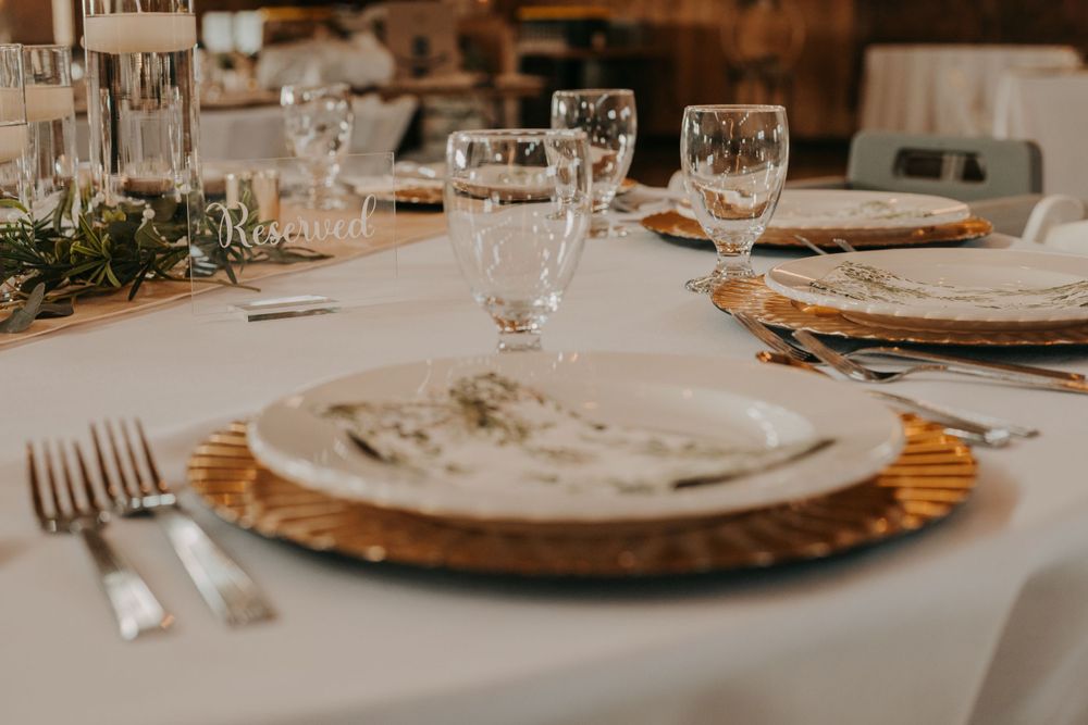 An elegant table setting with gold charger plates and crystal glasses for a formal event.