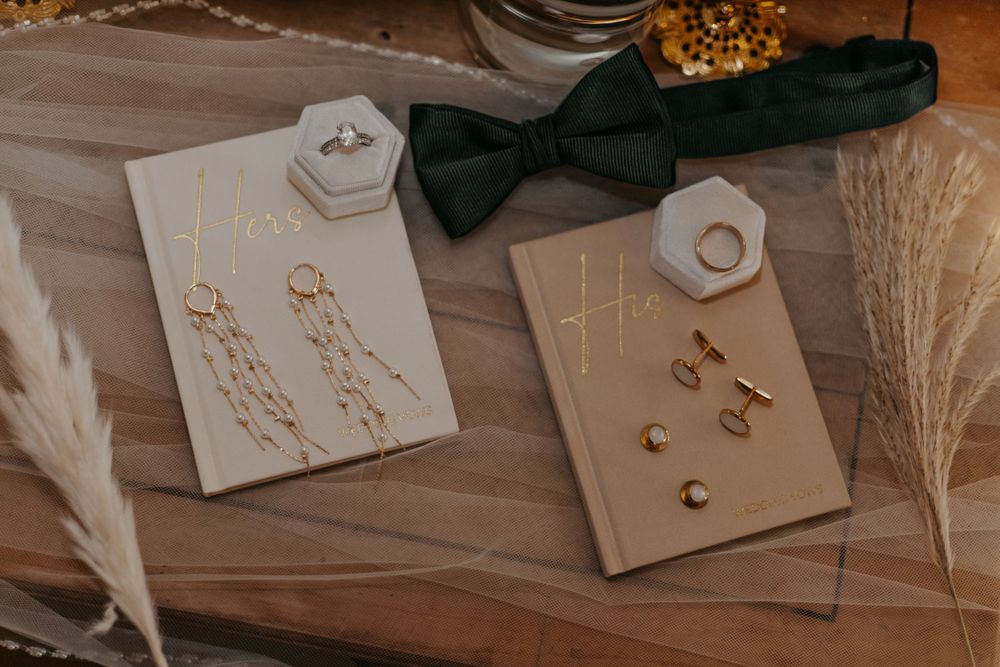 Wedding accessories including bow tie and jewelry displayed with pampas grass.