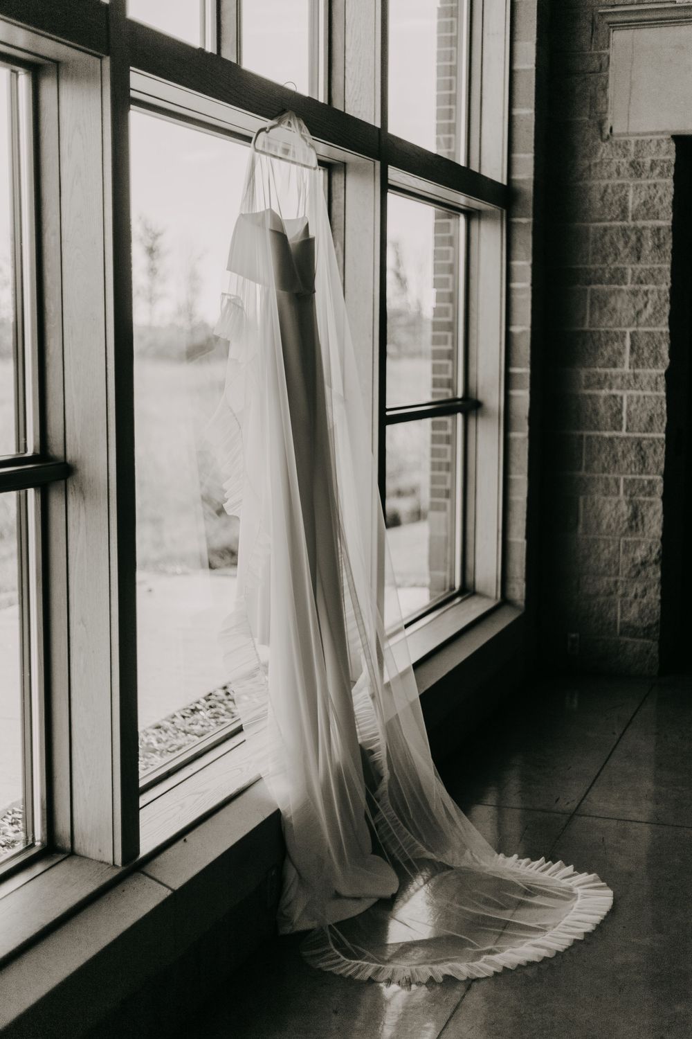 A black and white triptych showing white curtains billowing against tall windows in an empty hallway.