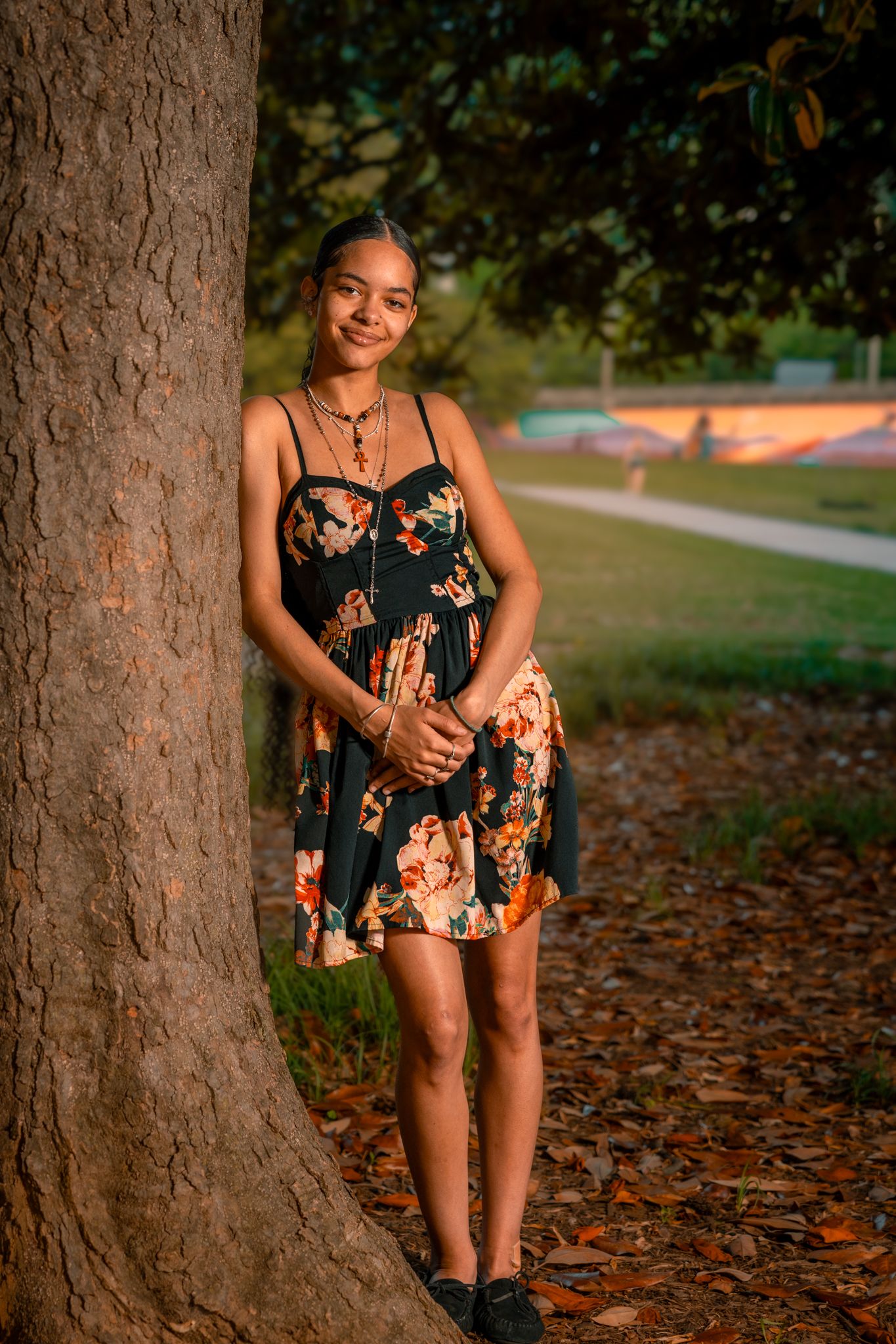 Portrait photo of a teen girl leaning against a tree